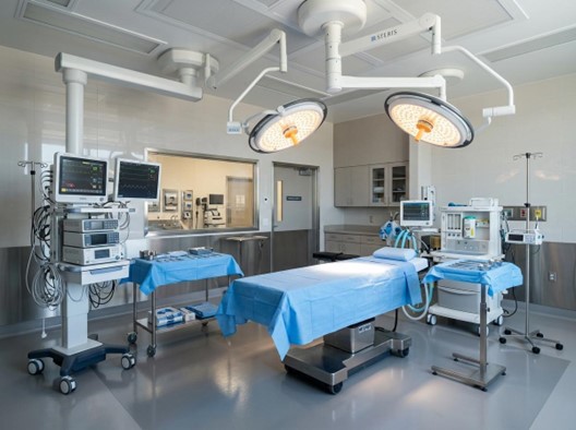 Modern rhinoplasty surgical equipment setup in sterile operating room with monitors and surgical lights