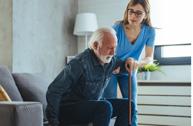 A home carer supporting an elderly man at home