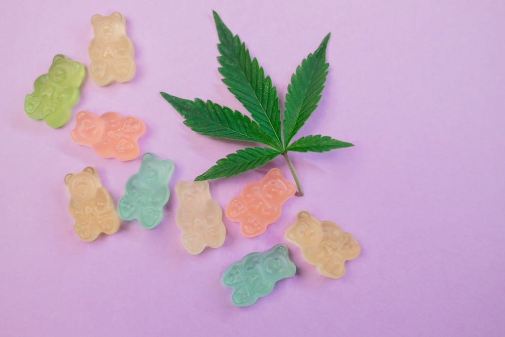 CBG gummies on a purple background with a cannabis leaf